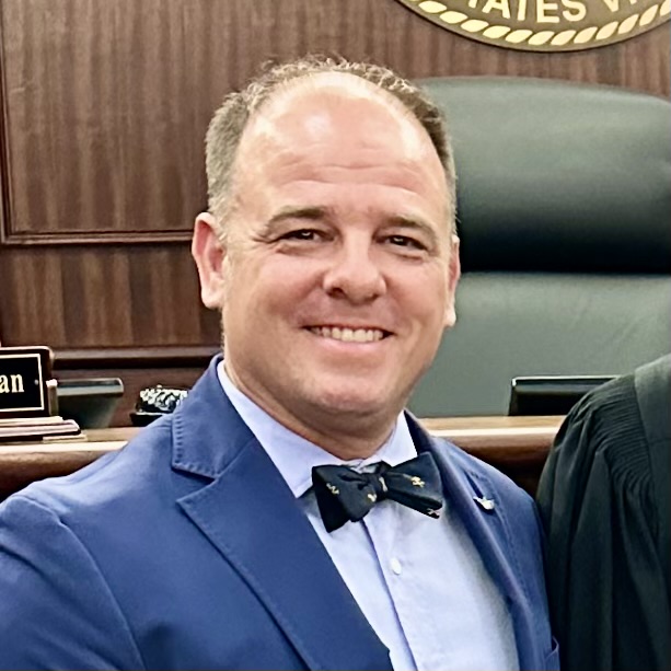 A photo of Mike Spivey, smiling and wearing a suit